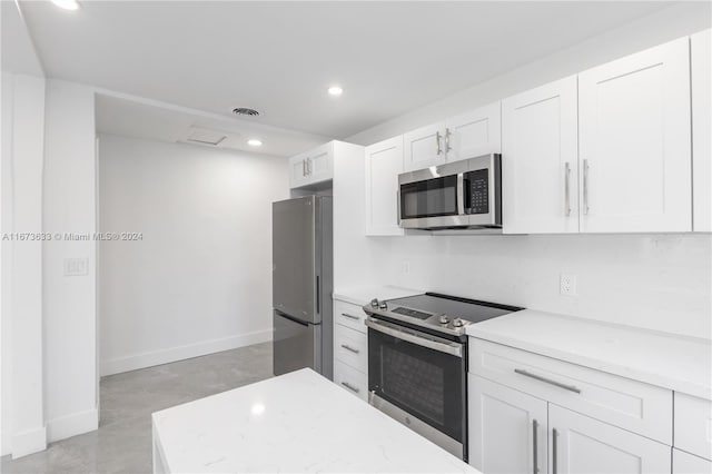 kitchen with white cabinetry, light stone countertops, and stainless steel appliances