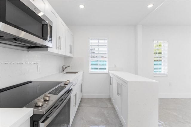 kitchen featuring sink, white cabinets, kitchen peninsula, and stainless steel appliances