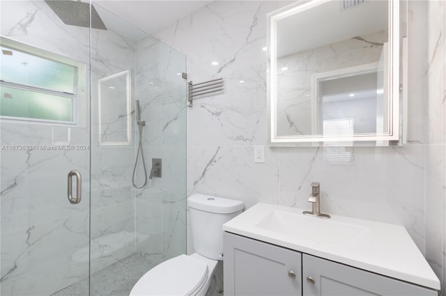 bathroom featuring tile walls, vanity, toilet, and an enclosed shower