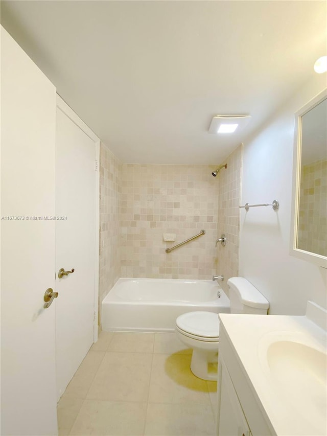 full bathroom featuring tile patterned flooring, tiled shower / bath, vanity, and toilet