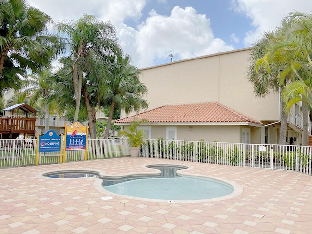 view of pool with a patio and a hot tub