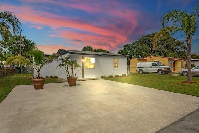 view of front facade with a lawn and a patio