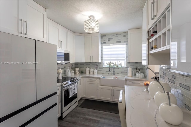 kitchen featuring dark hardwood / wood-style floors, stainless steel appliances, tasteful backsplash, sink, and white cabinetry