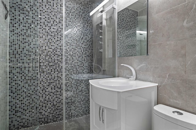 full bath featuring toilet, a shower stall, tile walls, and vanity