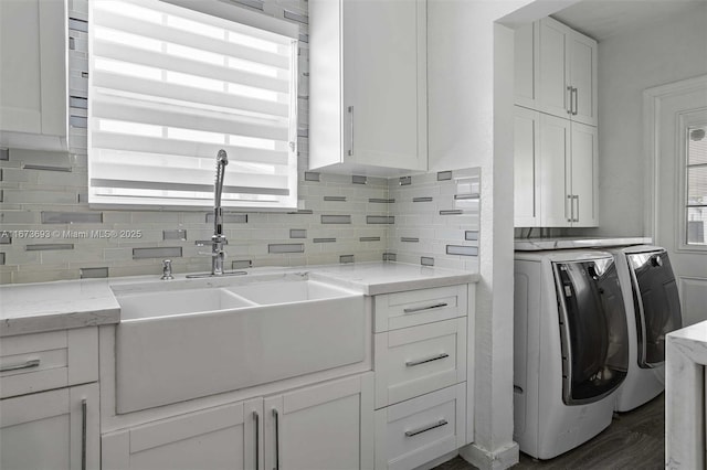 laundry area with separate washer and dryer, dark wood-type flooring, a sink, and cabinet space