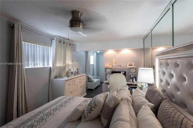 bedroom with ceiling fan, dark hardwood / wood-style flooring, and a textured ceiling