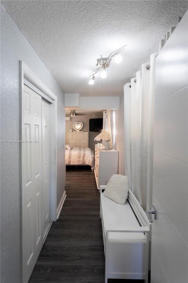 interior space featuring ceiling fan, a closet, dark hardwood / wood-style floors, and a textured ceiling