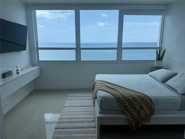 bedroom with a water view and tile patterned floors