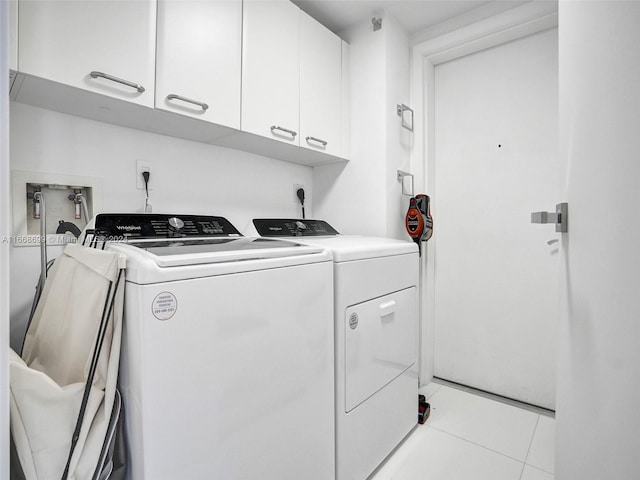 laundry area featuring washer and dryer, cabinets, and light tile patterned floors