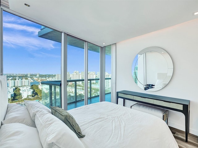 bedroom with a water view, hardwood / wood-style floors, and floor to ceiling windows