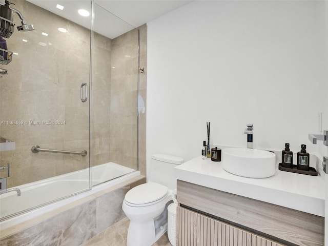 full bathroom featuring vanity, tile patterned flooring, toilet, and combined bath / shower with glass door