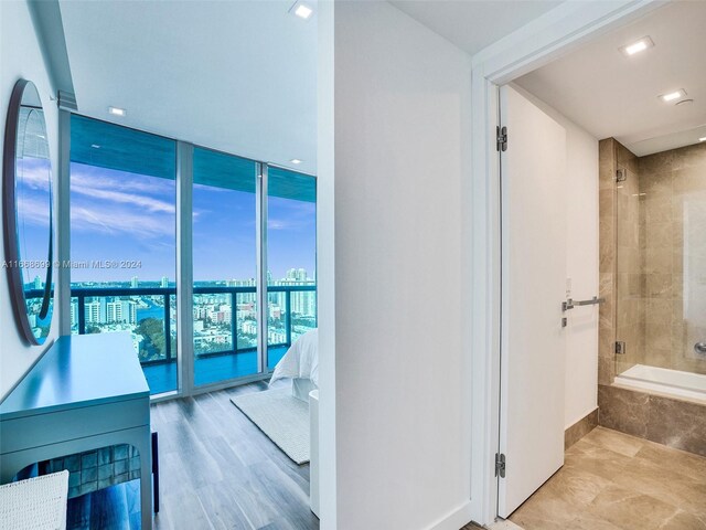 hallway with light wood-type flooring and floor to ceiling windows