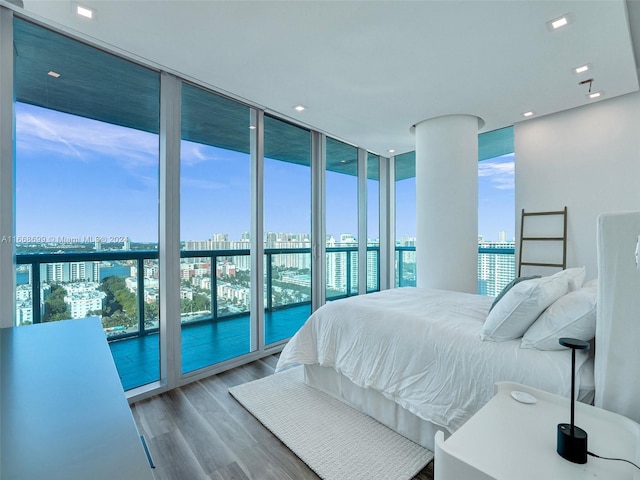 bedroom featuring wood-type flooring and a wall of windows