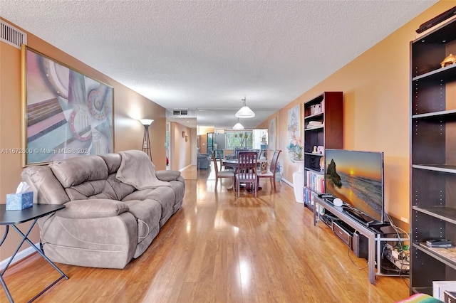 living room featuring a textured ceiling and light hardwood / wood-style floors