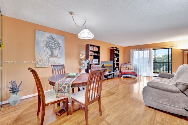 dining area featuring a textured ceiling and wood-type flooring