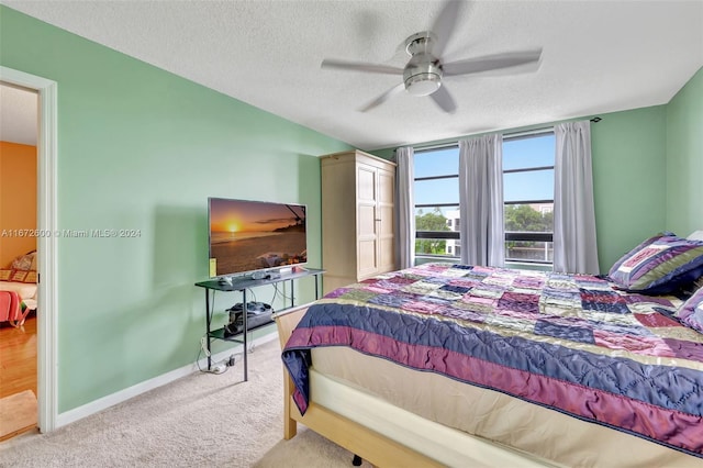 bedroom with light carpet, a textured ceiling, and ceiling fan