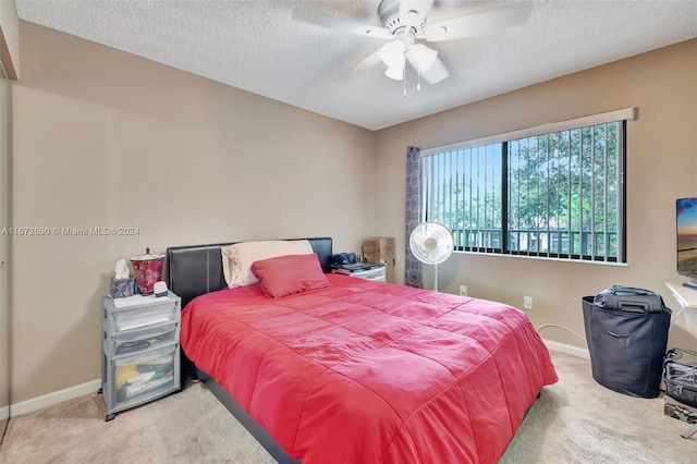 carpeted bedroom featuring a textured ceiling and ceiling fan