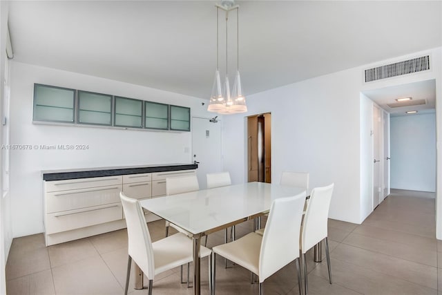 tiled dining room with a chandelier