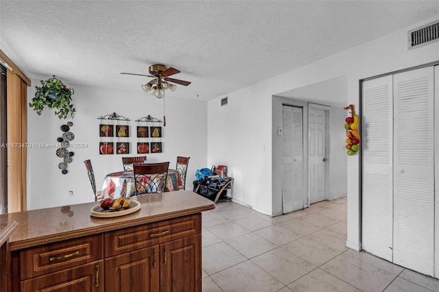 kitchen featuring a textured ceiling and ceiling fan