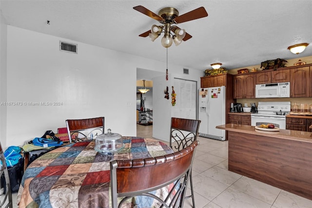 dining area featuring ceiling fan and a textured ceiling