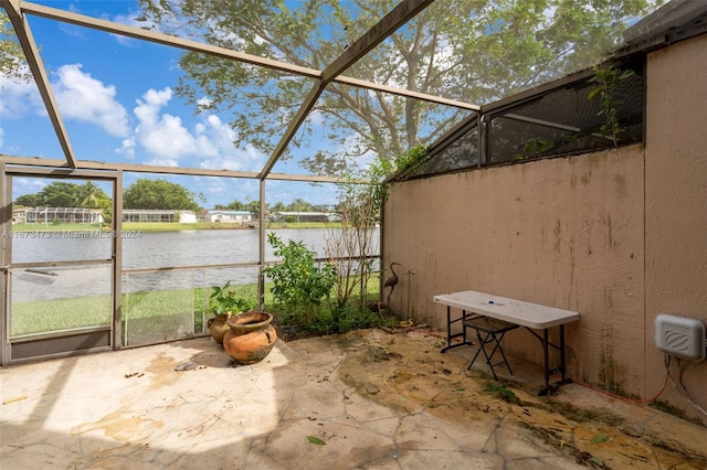 view of patio / terrace with a water view and glass enclosure