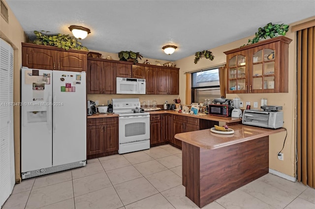 kitchen featuring kitchen peninsula, white appliances, and a textured ceiling