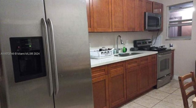 kitchen featuring light tile patterned floors, sink, and stainless steel appliances