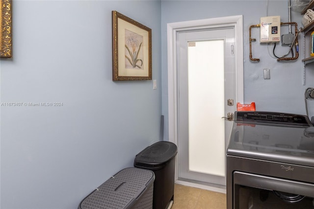 clothes washing area featuring washer / dryer and light tile patterned floors