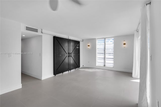 tiled spare room with a barn door