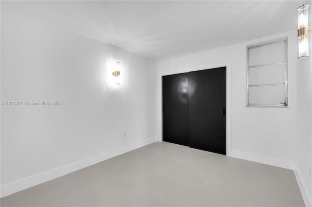 unfurnished bedroom featuring a closet and light tile patterned floors