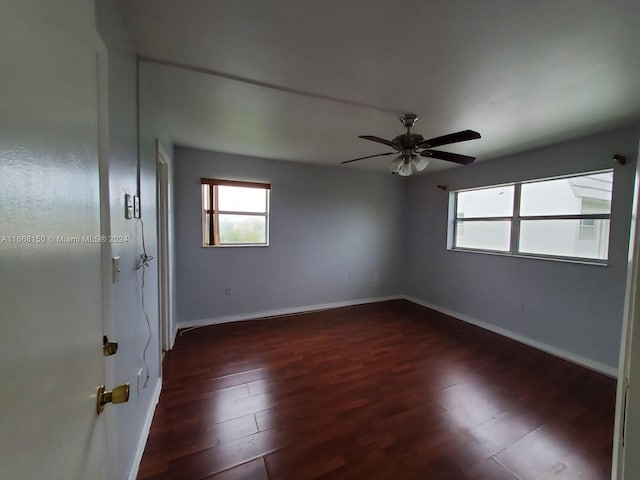 empty room featuring dark wood-type flooring and ceiling fan