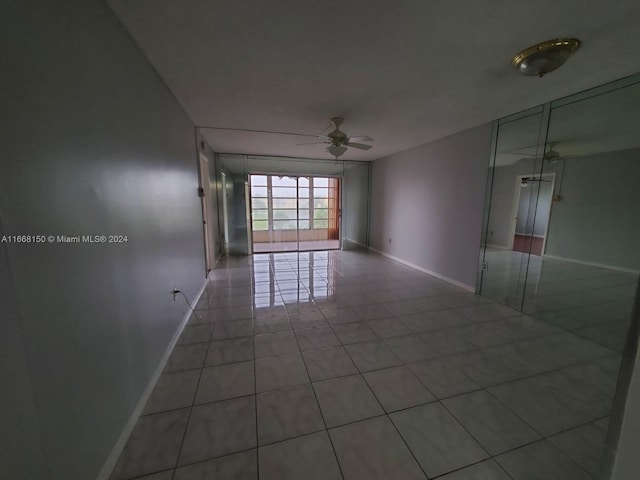 empty room with ceiling fan and tile patterned flooring