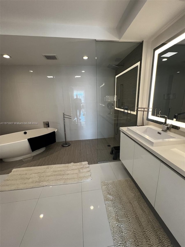 bathroom featuring tile patterned flooring, separate shower and tub, and vanity