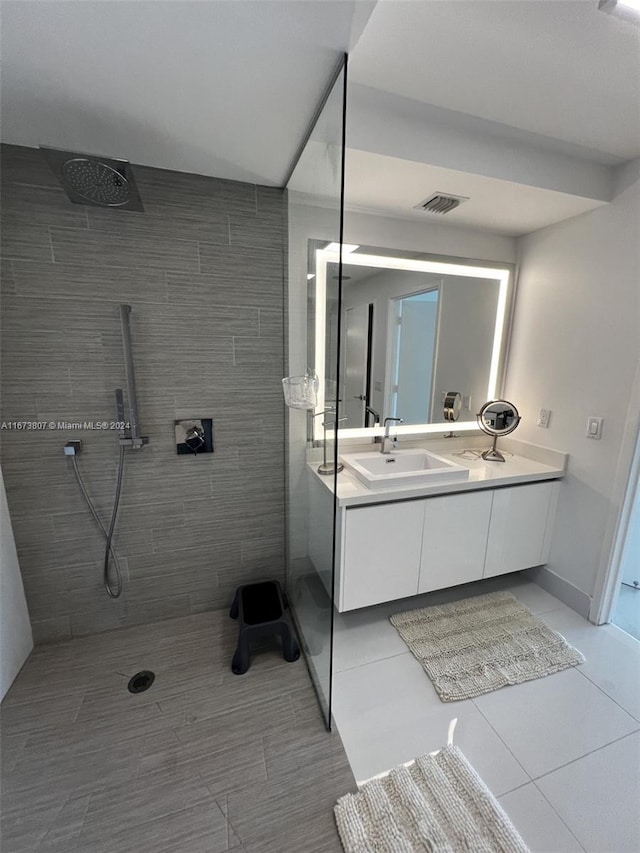 bathroom featuring tiled shower and vanity