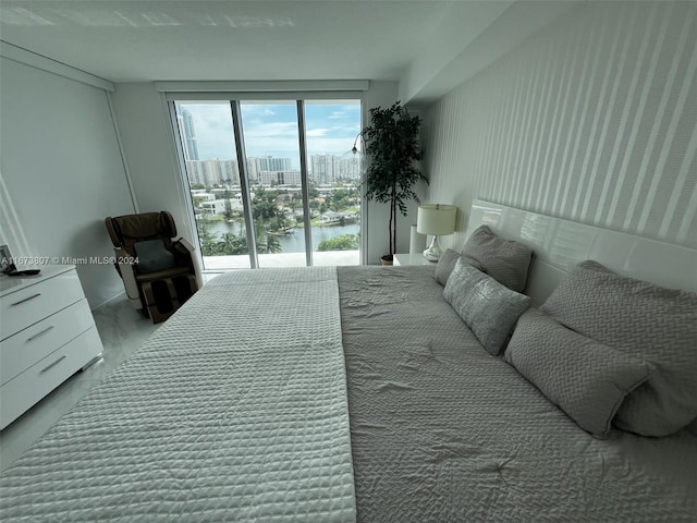 bedroom with access to exterior and a water view