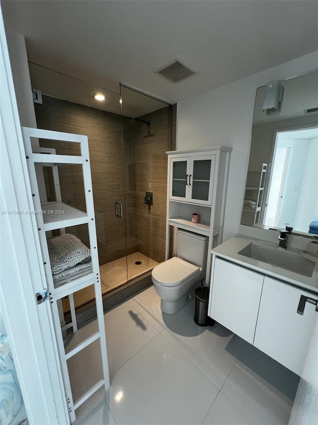 bathroom with vanity, tile patterned flooring, toilet, and an enclosed shower