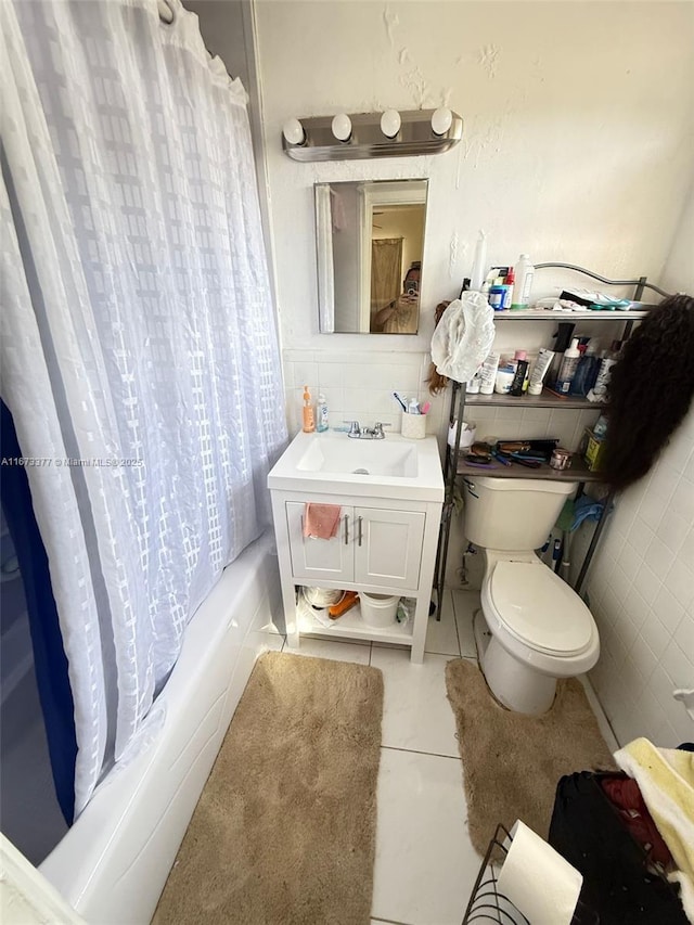 full bathroom featuring shower / tub combo with curtain, tile walls, toilet, vanity, and tile patterned flooring