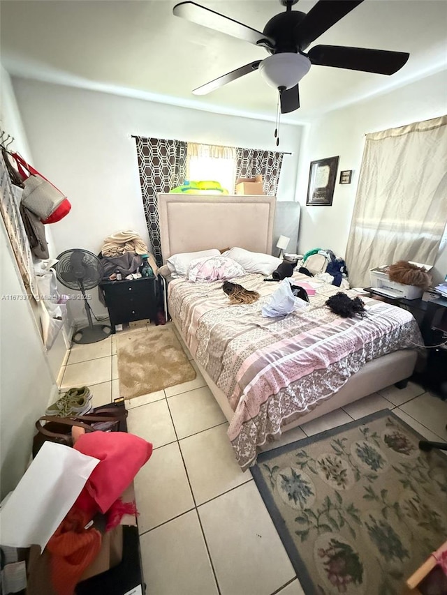 tiled bedroom featuring ceiling fan