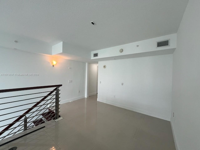 unfurnished room with a textured ceiling