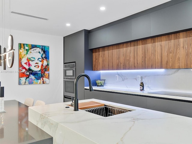 kitchen featuring black electric cooktop, light stone countertops, sink, pendant lighting, and backsplash