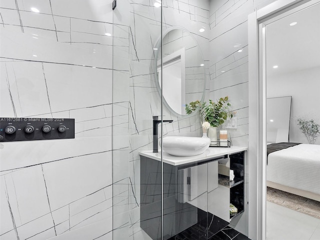 bathroom with a tile shower and vanity