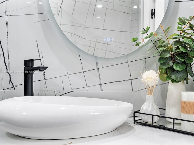 bathroom featuring sink and tile walls