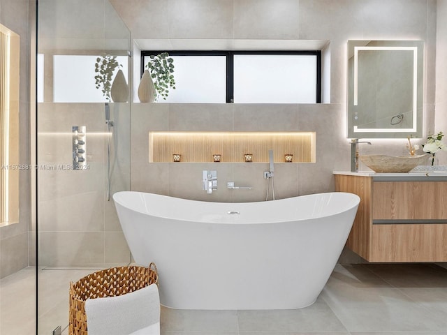 bathroom featuring a healthy amount of sunlight, tile walls, and vanity