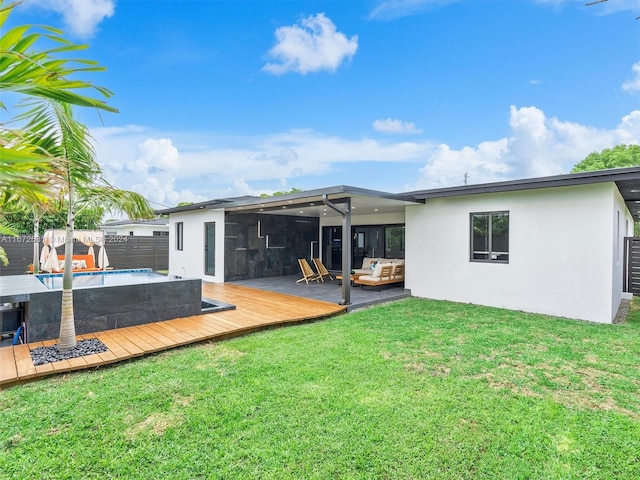 back of property with outdoor lounge area, a yard, and a swimming pool side deck