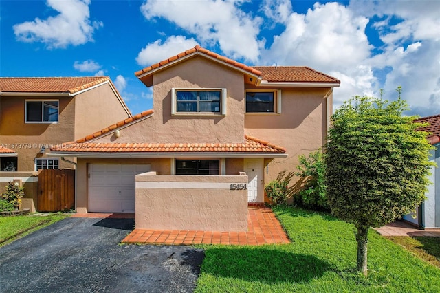 mediterranean / spanish home featuring a front yard and a garage