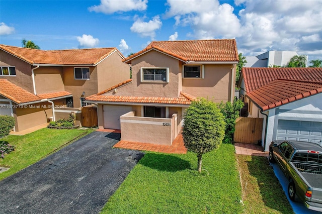 mediterranean / spanish home featuring a front lawn and a garage