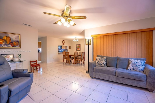 living room featuring ceiling fan with notable chandelier and light tile patterned floors