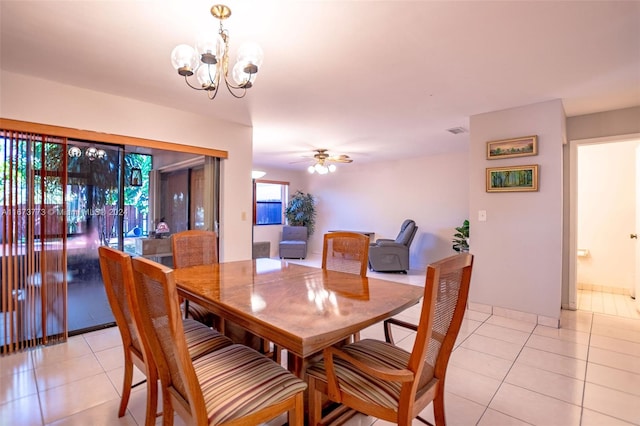 tiled dining area featuring ceiling fan with notable chandelier