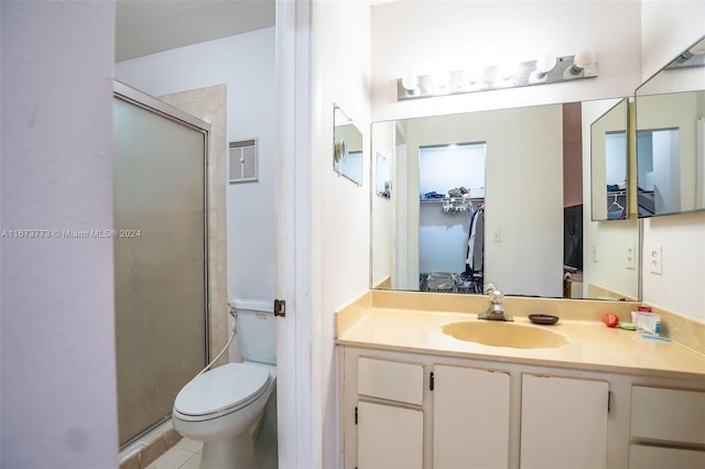 bathroom with tile patterned flooring, a shower with shower door, vanity, and toilet