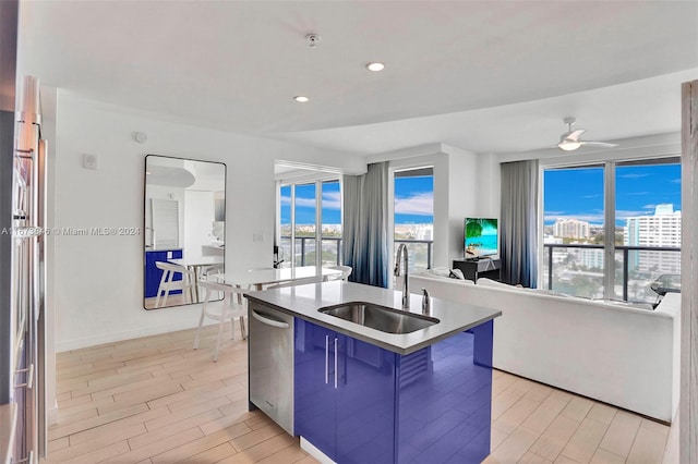 kitchen with light hardwood / wood-style flooring, sink, stainless steel appliances, an island with sink, and a kitchen bar